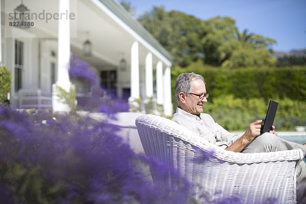 Senior Mann mit digitalem Tablett im Garten