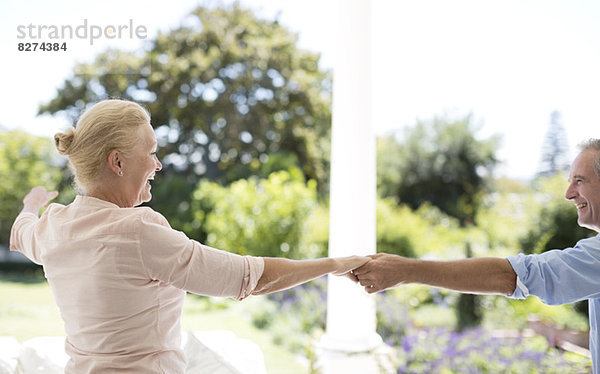 Seniorenpaar tanzt auf der Terrasse