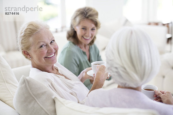 Seniorinnen trinken Kaffee auf dem Sofa