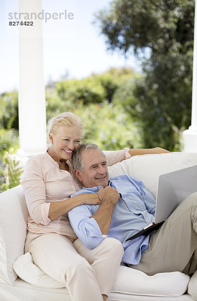 Senior Paar mit Laptop auf der Terrasse Sofa