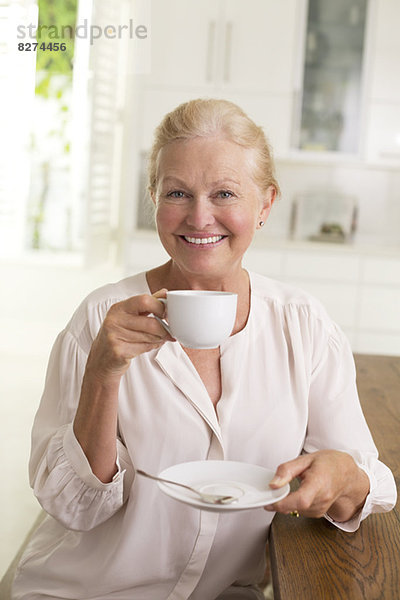 Porträt einer älteren Frau beim Kaffeetrinken