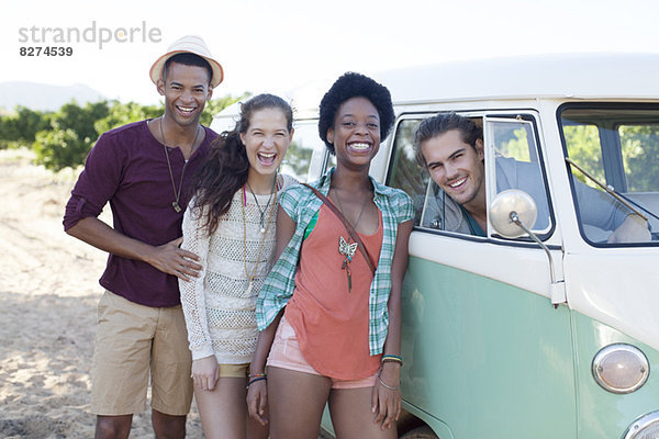 Freunde lachen mit dem Wohnmobil