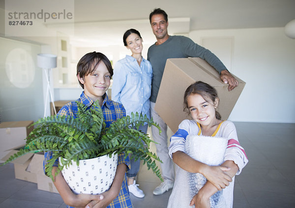 Porträt eines lächelnden Familienbesitzes im neuen Haus