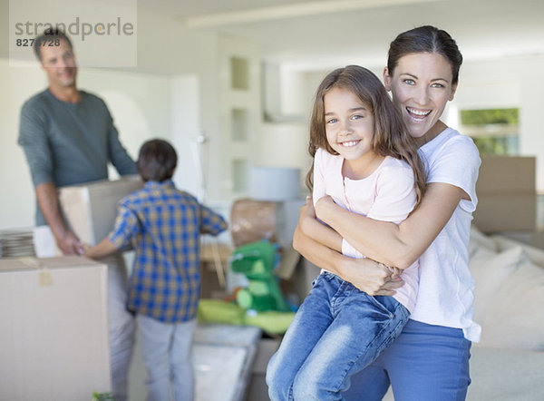 Mutter und Tochter umarmen sich im neuen Haus