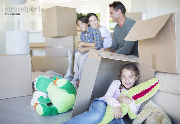 Familie unter den Kartons im Wohnzimmer