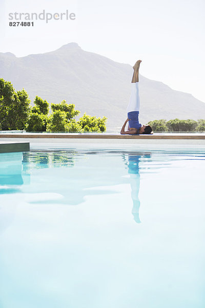 Frau beim Yoga am Pool