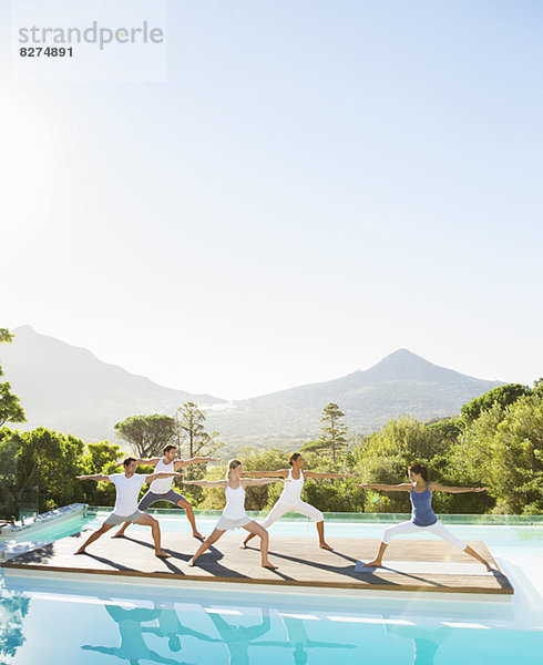 Menschen  die Yoga am Pool praktizieren