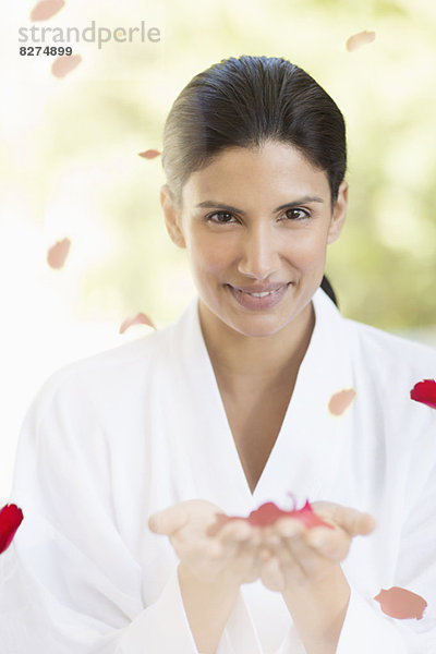 Porträt einer lächelnden Frau mit Rosenblättern