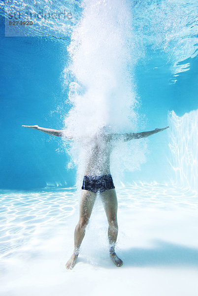 Mann steht unter Wasser im Schwimmbad