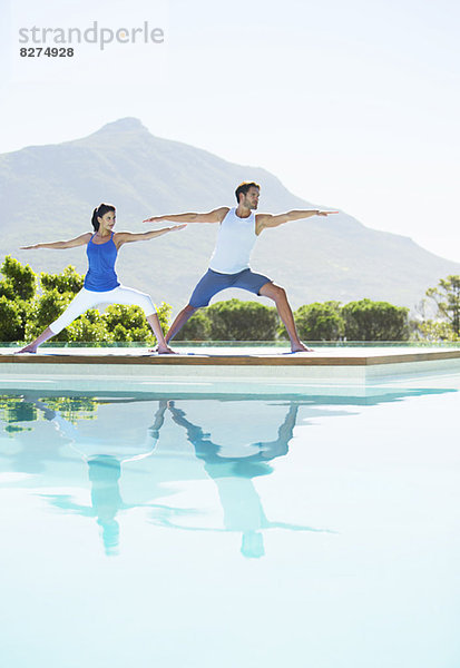 Paar beim Yoga am Pool