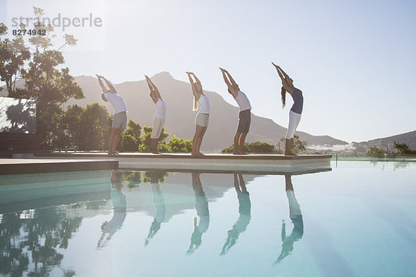 Menschen  die Yoga am Pool praktizieren