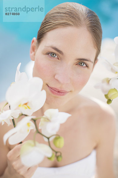 Frau mit Blumen am Pool