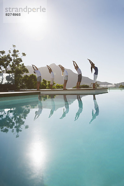 Menschen  die Yoga am Pool praktizieren