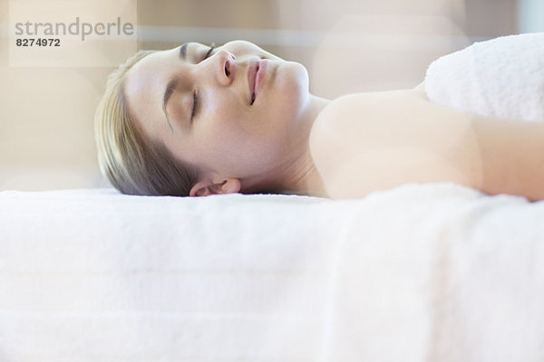 Frau auf dem Massagetisch im Spa liegend