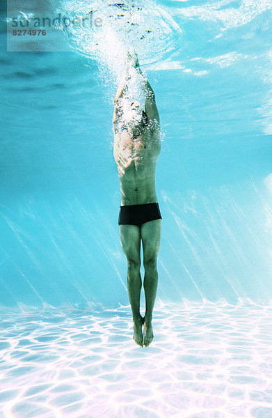 Mann unter Wasser im Schwimmbad