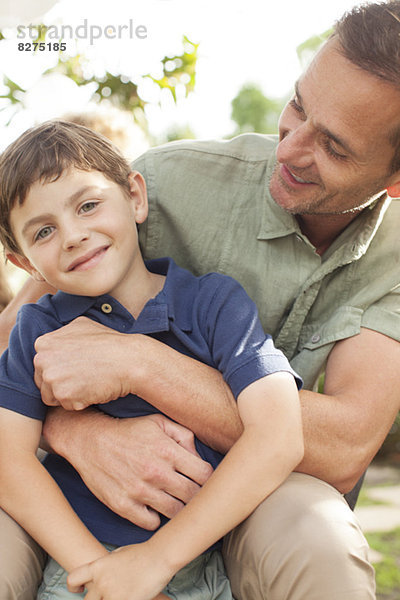 Vater und Sohn umarmen sich im Freien