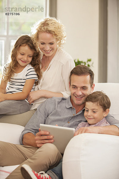 Familie mit digitalem Tablett auf dem Sofa