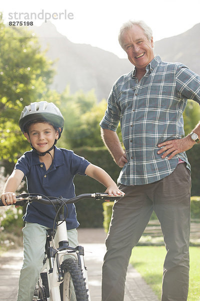 Älterer Mann lehrt Enkel Fahrrad fahren