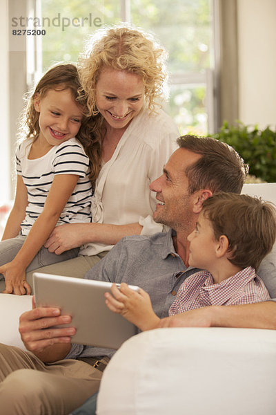 Familie mit digitalem Tablett auf dem Sofa