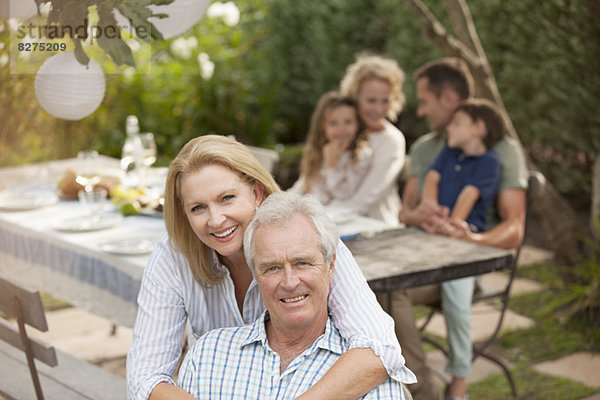 Porträt eines lächelnden Seniorenpaares beim Familienpicknick