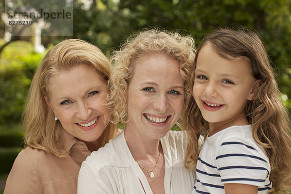 Drei Generationen von Frauen lächeln im Freien