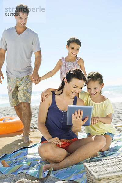 Familie mit digitalem Tablett am Strand