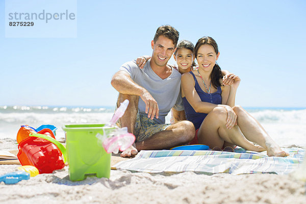 Porträt einer lächelnden Familie am Strand sitzend