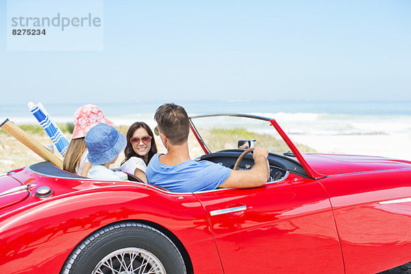 Familie fährt Cabriolet zum Strand