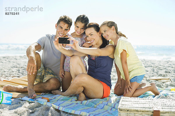 Familie beim Selbstporträt am Strand