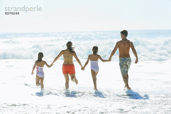 Familie beim Surfen am Strand