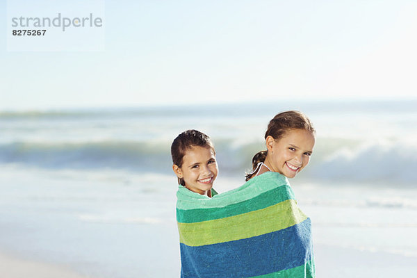 Mädchen in Handtuch gewickelt am Strand