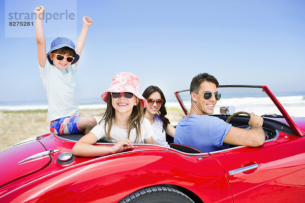 Familie im Cabrio am Strand