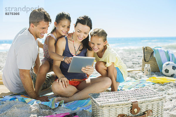 Familie mit digitalem Tablett am Strand