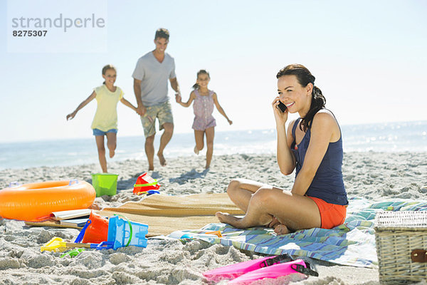 Frau beim Telefonieren am Strand