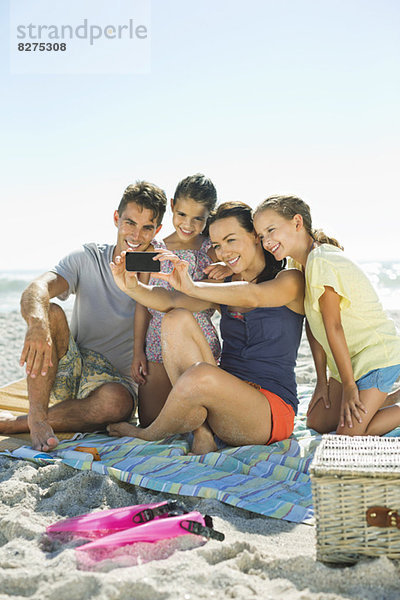 Selbstbildnis der Familie mit Fotohandy am Strand