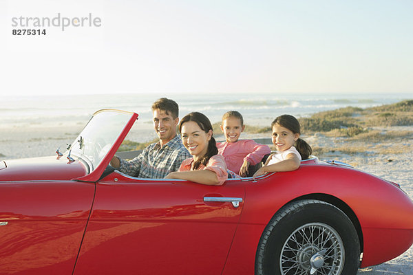 Familie im Cabrio am Strand