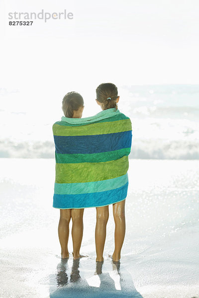 Mädchen in Handtuch gewickelt am Strand