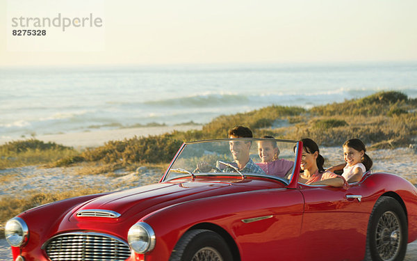 Familie im Cabrio am Strand