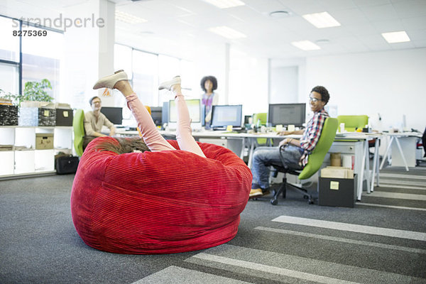 Geschäftsfrau beim Spielen im Sitzsack im Büro