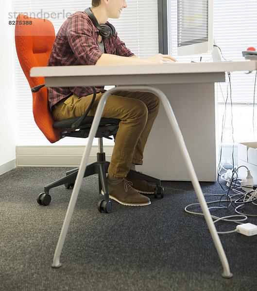 Geschäftsmann mit Computer am Schreibtisch im Büro