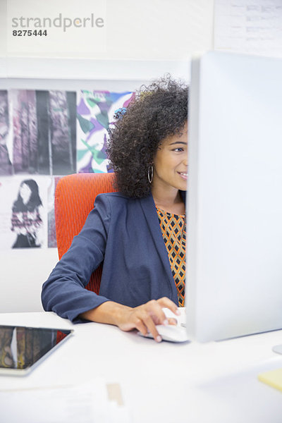 Geschäftsfrau  die am Computer am Schreibtisch arbeitet