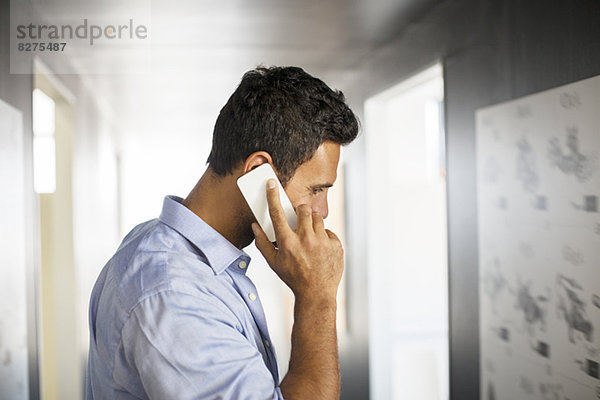 Geschäftsmann beim Telefonieren auf dem Flur