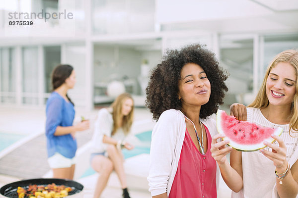 Frauen essen Wassermelone beim Grillen