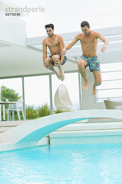 Männer beim Sprung ins Schwimmbad
