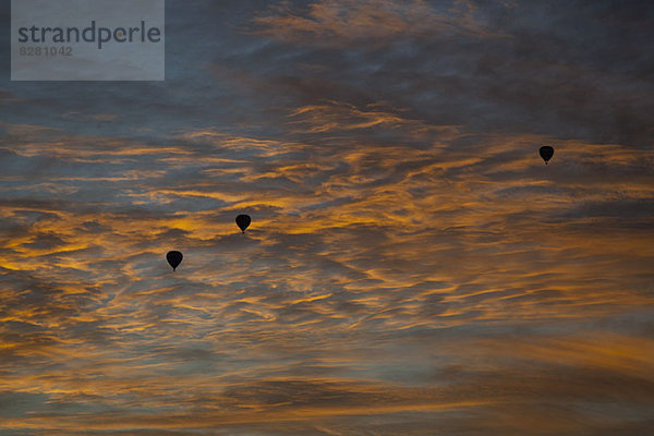 Drei silhouettierte Heißluftballons gegen einen Dämmerungshimmel in Melbourne  Victoria  Australien