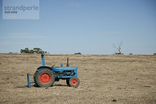 Traktor auf leerem Feld