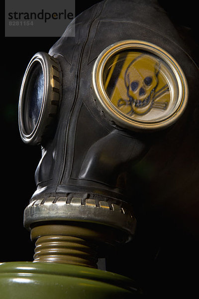 Eine Gasmaske mit einem Totenkopf und einem Warnschild in der Maske.