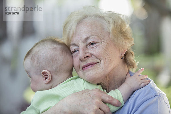 Eine Großmutter  die ihren Enkel umarmt.