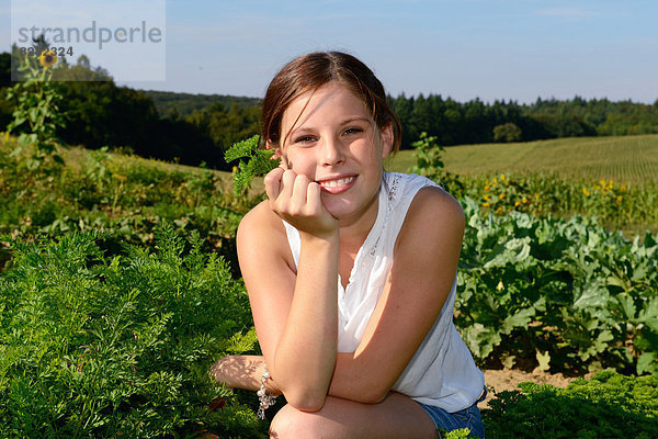 Lächelndes Mädchen im Gemüsegarten