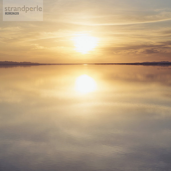 Seichtes Wasser über der Oberfläche der Bonneville Salt Flats  bei Sonnenuntergang.